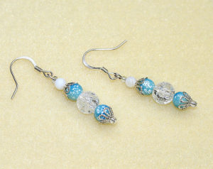 Elegant drop earrings with natural clear white crackle quartz, white mother of pearl shell, and speckled blue glass