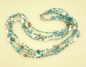 Beach themed multi strand necklace with nassa shells and seed beads